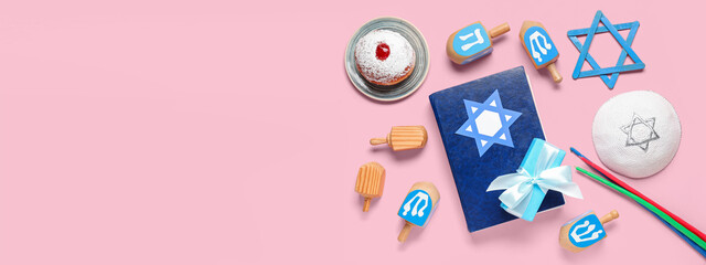 Torah, gift, dreidels, candles and donut on pink background with space for text. Hannukah...