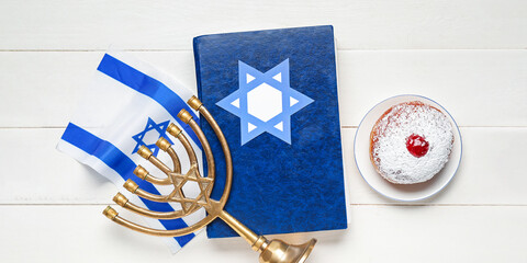 Tasty donut, Torah, flag of Israel and hanukkiah on white wooden background. Hannukah celebration