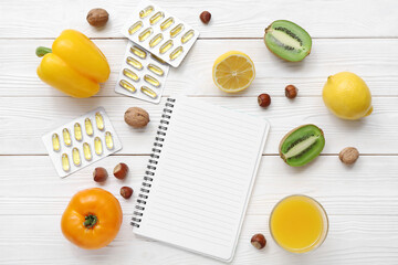Composition with blank notebook, pills and healthy products on white wooden background