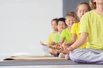 Fotobehang Group of little children meditating in gym © Pixel-Shot