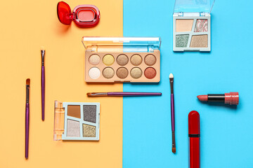 Beautiful palettes of eyeshadows and different decorative cosmetics on colorful background