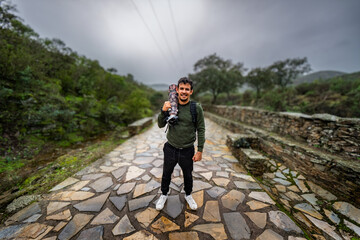 Latino adventurer, camera in hand, braves autumn rain along Monfragüe trail.