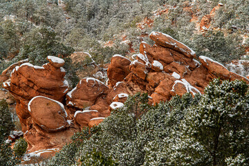 Surreal  rock pinnacles with red rock sand stone towers surrounded by scrub oak, pine trees and...