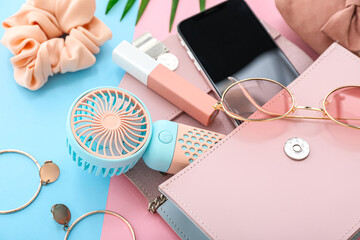 Composition with portable electric fan, modern mobile phone and stylish female accessories on color...