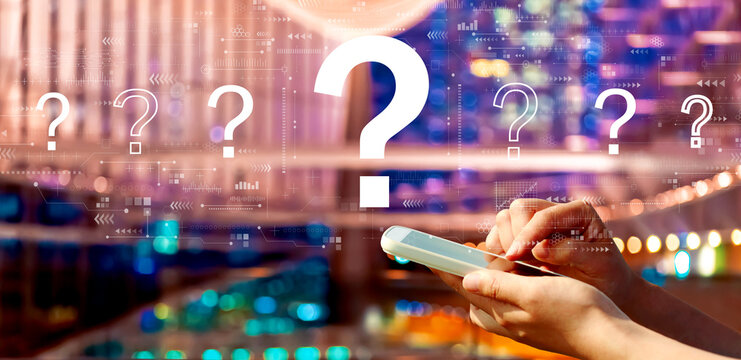 Question marks with person using a smartphone in a city at night