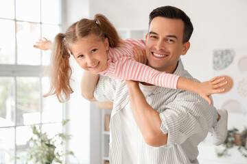 Cute little girl with her dad having fun at home