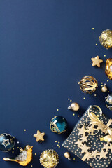 Elegant navy Christmas background with gold glitter baubles, gift box, stars. Perfect mockup for holiday cards and invitations