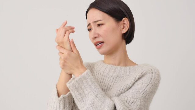 手が痺れる中年女性　白背景