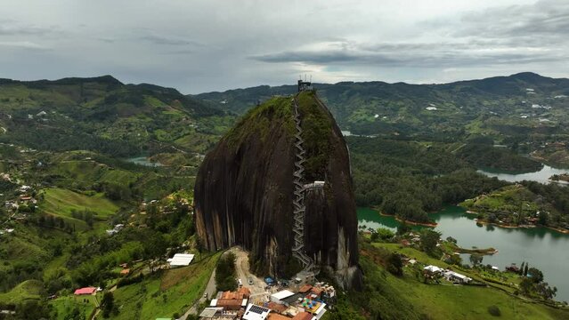 Drone shot around the Piedra del Peñol monolith, in cloudy Guatape, Colombia