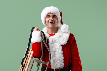 Santa Claus with sledge on green background