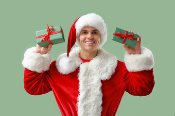 Santa Claus with gift boxes on green background