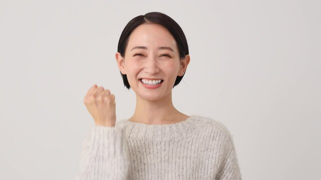 ガッツポーズする中年女性　白背景