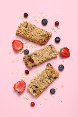 Tasty granola bars and ingredients on pink background, flat lay