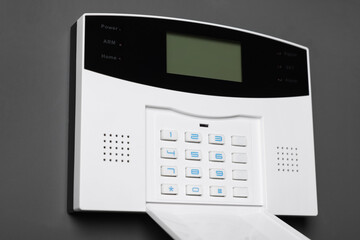 Home security alarm system on gray wall, closeup