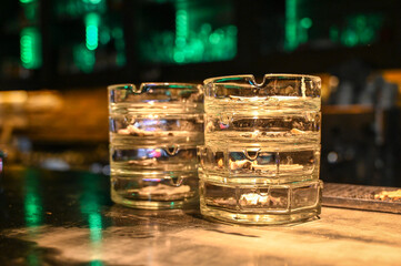 Glass ashtray on the table in the club. Cigarette ashtrays.