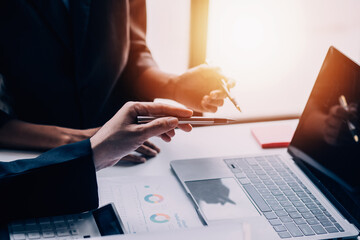 Financial analysts analyze business financial reports on a digital tablet planning investment project during a discussion at a meeting of corporate showing the results of their successful teamwork.