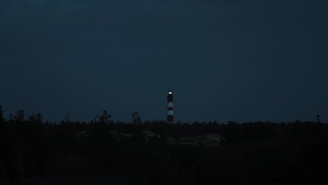 Darkness descended, in distance lighthouse sends it&rsquo;s signal out to sea