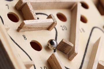 Wooden toy maze with metal ball, closeup