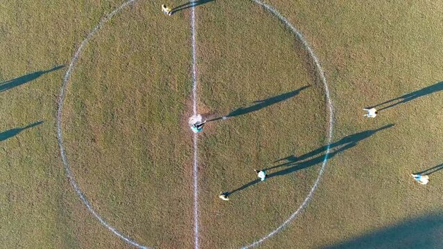 Aerial view of an initial kickoff in an amateur soccer game in South America.