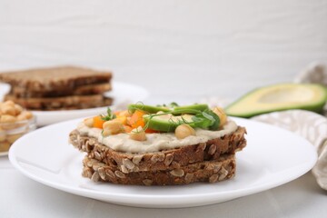 Tasty vegan sandwich with avocado, chickpeas and bell pepper on white table, closeup