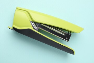 One bright stapler on light blue background, top view