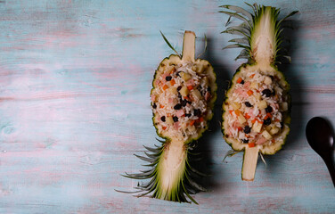 Two pieces of pineapple served with baked rice.