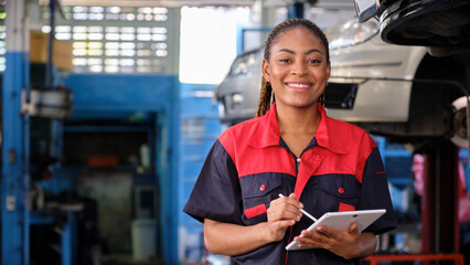 Happy Black female supervisor mechanic, cheerful smile, inspects repair work checklists with tablet at garage, service car maintenance, and fixing specialist occupations in auto transport industry. - obrazy, fototapety, plakaty