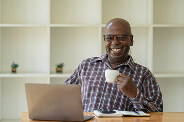 Fototapeta na wymiar Happy Mature Black Man Drinking Coffee while relaxing at home. Retirement Lifestyle And Leisure Concept.