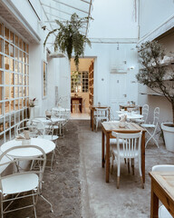 Restaurante antiguo, con sillas y mesas de madera y blancas.