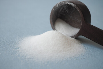 Coarse salt pouring from a wooden spoon . - obrazy, fototapety, plakaty