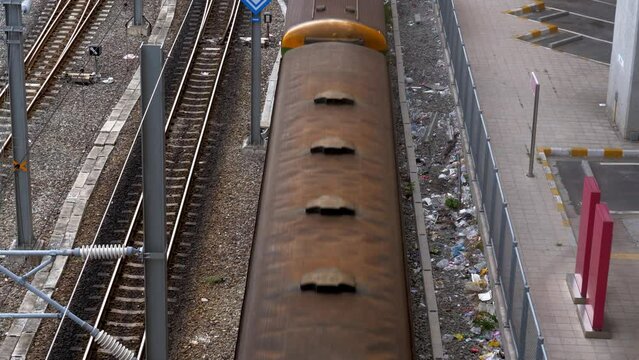 A multi-car train running on a railroad viewed in high angle showing train's roof.