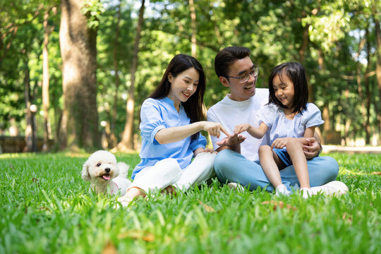 Photo of young Asian family at park