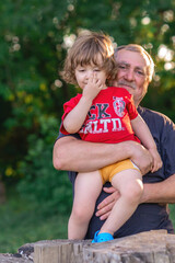 Grandson and grandfather playing on the river bank