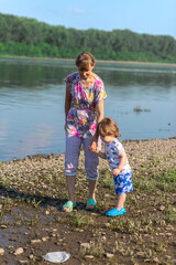 Grandson and grandmother playing on the river bank