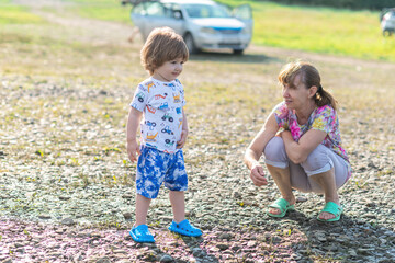 Grandson and grandmother playing on the river bank