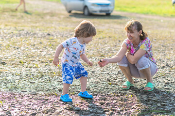Grandson and grandmother playing on the river bank