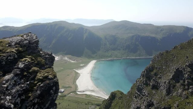Aerial revealing shot showing Hoddevik Beach and mountains with blue sea during sunny day, Norway - top down