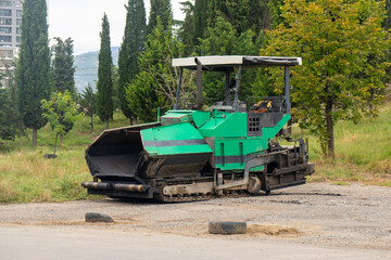 Asphalt paver machine. Asphalt finisher or paving machine placing a layer of asphalt