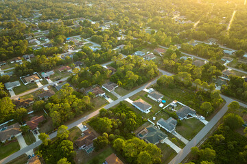 Aerial landscape view of suburban private houses between green palm trees in Florida quiet rural...