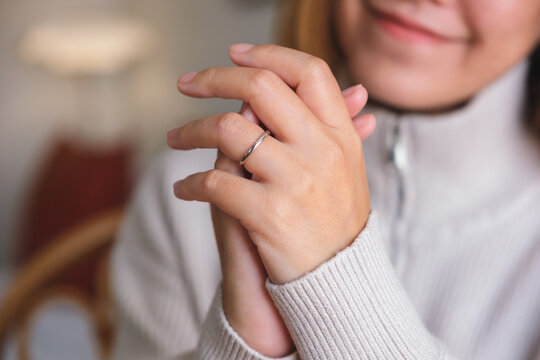 Closeup image of a young woman wearing silver ring on her finger