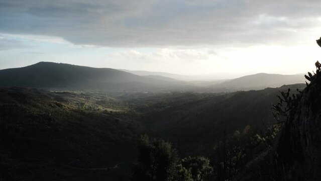 Landscape view from Sortelha Castle in Portugal with dark clouds and sun rays.