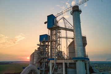 Cement plant with high factory structure and tower cranes at industrial production area. Manufacture and global industry concept - obrazy, fototapety, plakaty