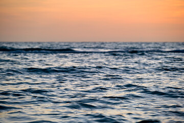 Obraz premium Dramatic red ocean waves at sunset with soft evening sea dark water