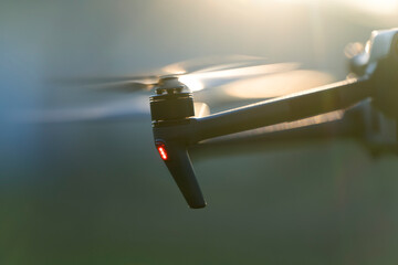 Drone aircraft with blurred fast rotating propellers and video camera flying in air