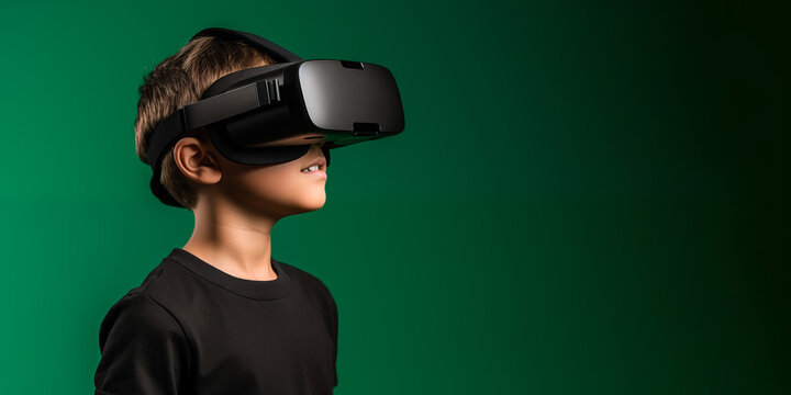 Young boy getting experience using VR headset glasses isolated on a green background with copy space - Powered by Adobe