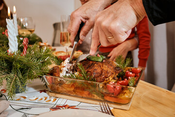 Christmas family dinner, Christmas decor, holiday table top view, celebrating the new year together, spread a hot dish, turkey leg, chicken in plates, close-up of hands cutting roast turkey