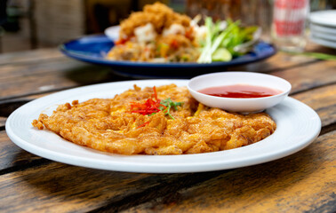 Minced pork omelet with chili sauce in Thai restaurant, popular Thai food and street food.
