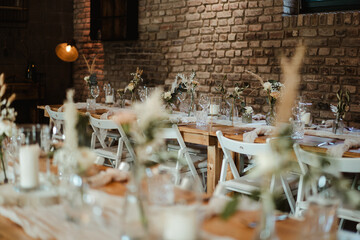 Wedding decoration with flowers and wooden tables and chairs in pastel colors 