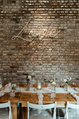 Love Sign - Wedding decoration with flowers and wooden tables and chairs in pastel colors 