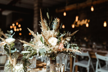 Wedding decoration with flowers and wooden tables and chairs in pastel colors 